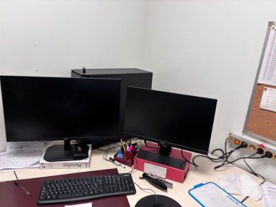 un bureau équipé de deux écrans et d'un clavier