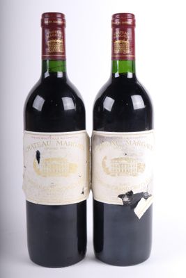 deux bouteilles de vin posées l'une à côté de l'autre sur une surface blanche