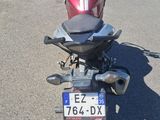 une moto garée sur un parking, avec une plaque d'immatriculation à l'arrière