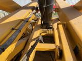 a man that is standing on the back of a bulldozer