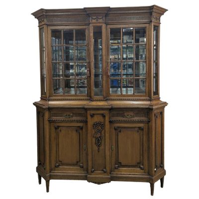 a large wooden china cabinet with glass doors and drawers