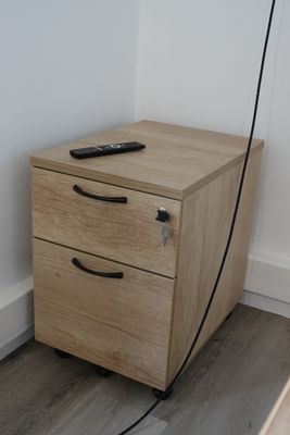 a wooden cabinet with a remote on top of it