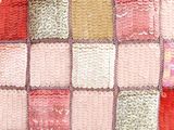 a crocheted blanket that is sitting on the floor