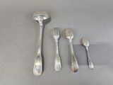 four spoons, a fork, and a spoon rest on a table