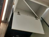 a white cabinet with a door open on the floor