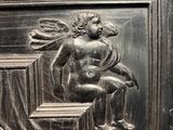 a close up of a metal door with a statue on it