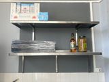 a metal shelf that has some bottles and plates on it
