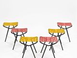 four stools with yellow, red, and yellow fabric on them
