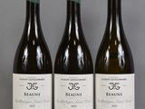 three bottles of wine are lined up on a table