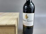 a bottle of wine sitting on a table next to a wooden box