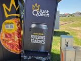 une poubelle sur laquelle est posée une pizza, à côté d'une autre poubelle