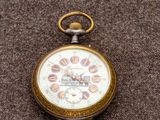 une montre de poche posée sur une surface marron