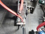 un tuyau rouge raccordé à une machine posée au sol