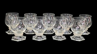 six clear wine glasses lined up in a row on a black background