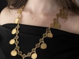the woman is wearing a black dress and a gold necklace