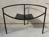 une table en verre surmontée d'un piètement en métal noir
