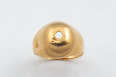 une image représentant une bague en or percée d'un trou au milieu