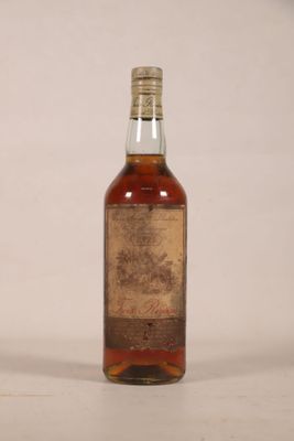 une vieille bouteille de whisky posée sur une table blanche