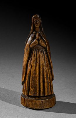 an old wooden statue of a woman with her hands crossed