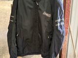 a black jacket hanging on a rack in a garage