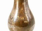 a brown vase that is sitting on a white surface