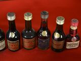 several bottles of liquor are lined up on a red surface