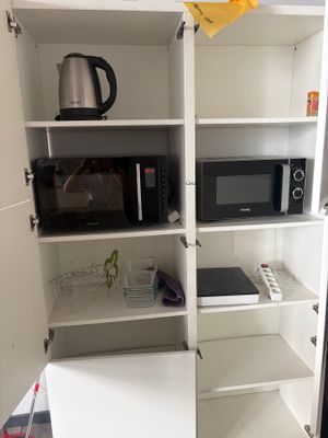 a microwave and a microwave oven in the corner of a cabinet