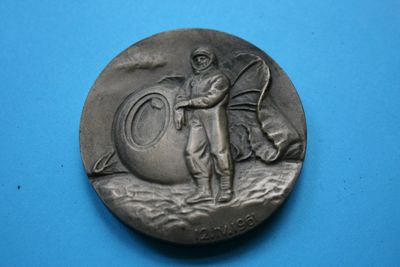 une image représentant une médaille d'argent sur laquelle figurent un homme et un chien