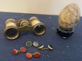 a pair of binoculars and a pair of earrings on a table