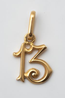 a close up of a gold charm with the number thirteen on it