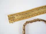 a gold bracelet and a gold bracelet on a white table