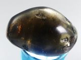a glass bottle with a rock on top of it