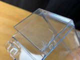 a person holding a clear box on a wooden table