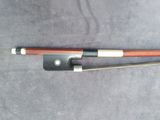 a close up of a violin bow and a bow rest on a table