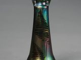 un vase vert orné d'un motif de fougère