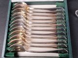 six forks in a box with a green case