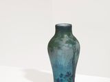 un vase bleu posé sur une étagère blanche dans une pièce