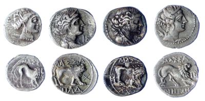 a close up of a bunch of ancient coins on a white surface
