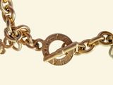 a close up of a gold bracelet with a key on it