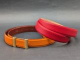 deux bracelets en cuir de couleurs différentes posés sur une surface grise