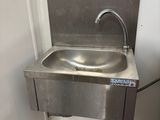 a sink in the corner of a bathroom with a faucet