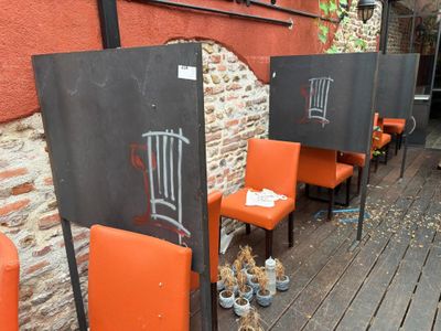 several orange chairs are lined up in front of a brick wall