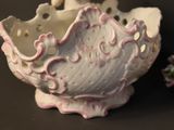a white and pink bowl and a strawberry on a table