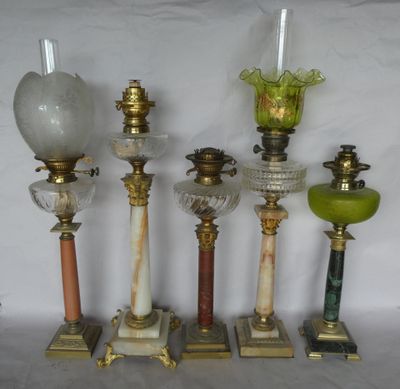 four antique lamps are lined up against a white background