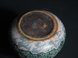 a close up of a vase on a black surface