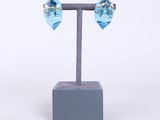 un gros plan sur une paire de boucles d'oreilles bleues posées sur un présentoir