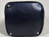 black leather purse with rivets and rivets sitting on a white surface