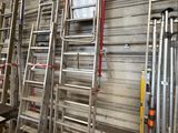 several ladders are lined up against a wall in a warehouse