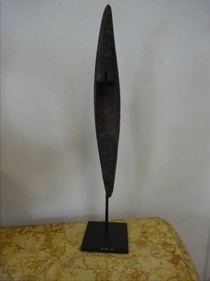 bronze sculpture of a bird on a stand on a yellow cushion