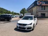 the white car is parked in front of a building with many cars parked in front of it